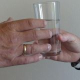 Person reicht einer anderen ein Glas Wasser